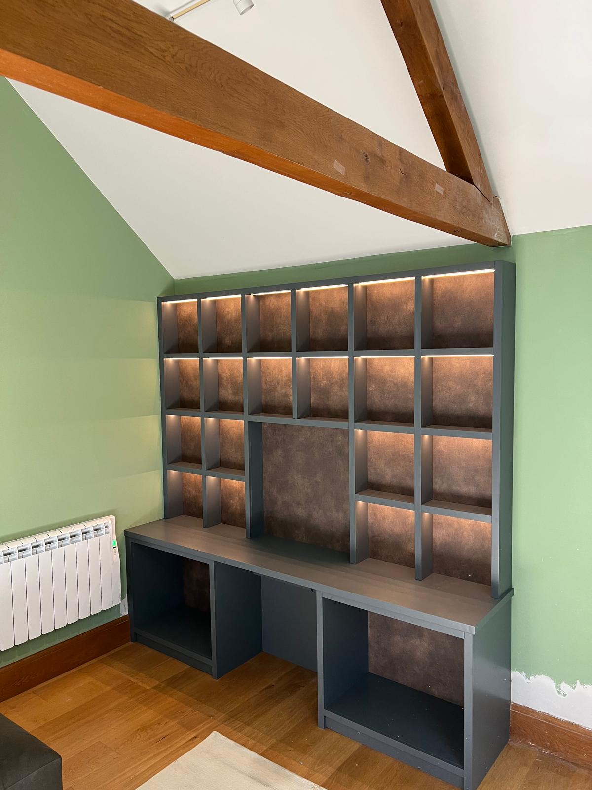 Fitted home office wall of pigeonhole shelving and desk in grey with oak detailing