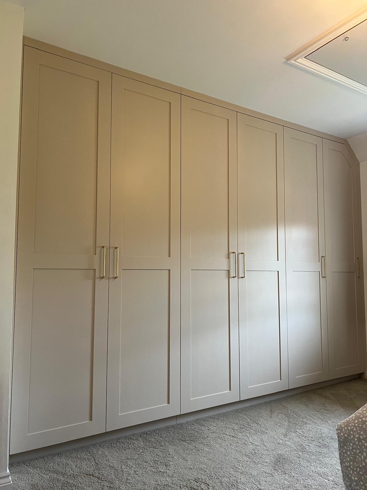 Six-door fitted wardrobes in cream running wall to wall in a bedroom, Wallingford