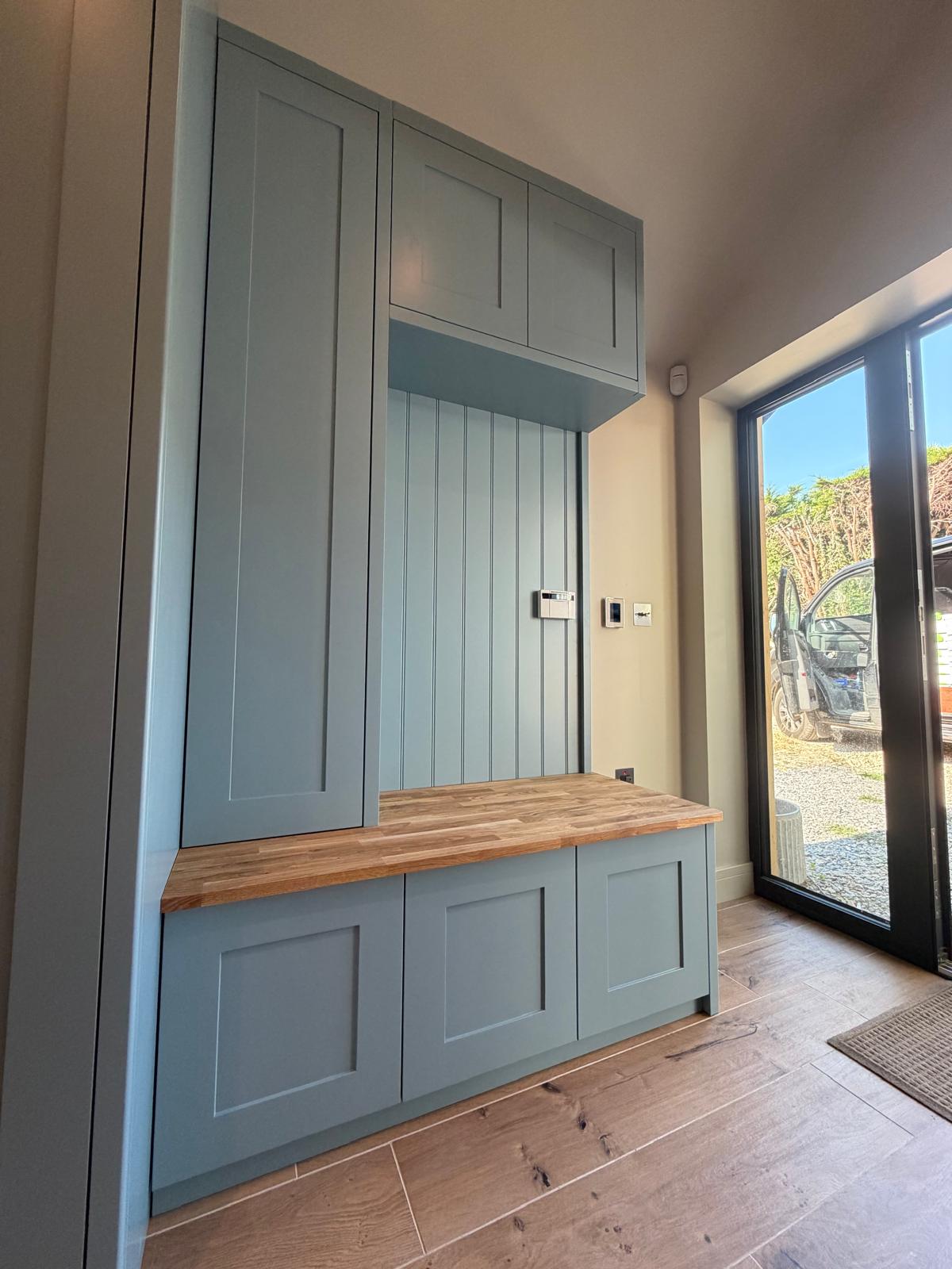 Fitted bootroom storage and oak-topped bench in a hallway, handmade in Oxfordshire