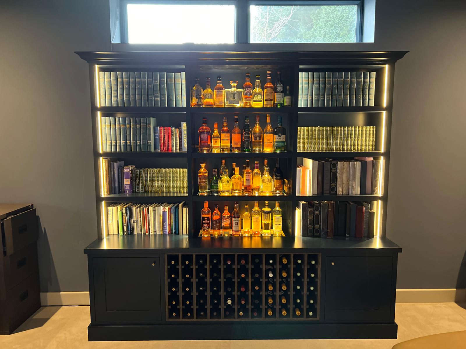 Bespoke dark blue bar unit with lit whisky shelving and integrated wine rack